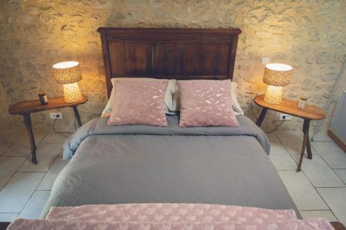 埃梅Les 3 C的一间卧室配有一张床,两台桌子上放着两盏灯