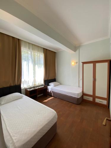 凯麦尔Erol Apart的酒店客房设有两张床和窗户。