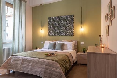 特尔尼Galvani Apartments的卧室配有一张床,墙上挂有绘画作品