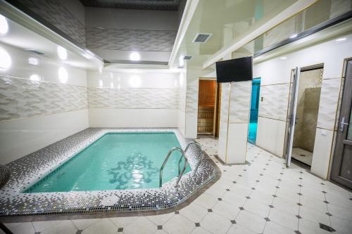 塔什干Leader Hotel的一间位于客房中间的大浴室,配有浴缸