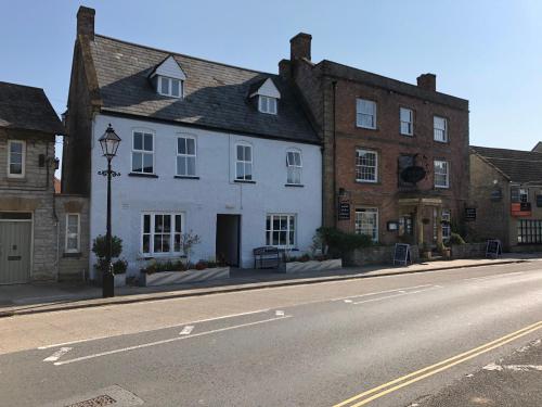 IlchesterThe Ilchester Arms Hotel, Ilchester Somerset的街道边的白色建筑