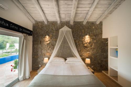 Curvatos蒙吉奥斯乡间别墅温泉酒店的石墙房间内的一张床位
