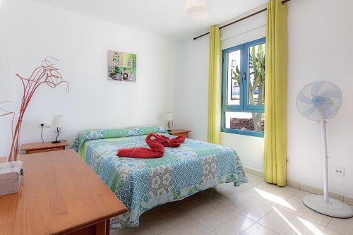 科斯塔特吉塞Apartamento Ideal Costa Teguise的一间卧室,床上有红色填充动物
