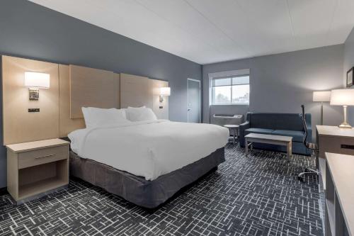 海恩尼斯Comfort Inn Hyannis - Cape Cod的酒店客房带一张大床和一把椅子