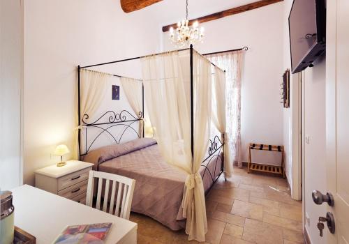 文蒂米利亚Casa Porta Marina的一间卧室配有一张天蓬床和一张桌子