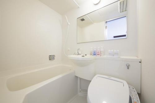 府中市府中市经济型酒店的白色的浴室设有卫生间和水槽。