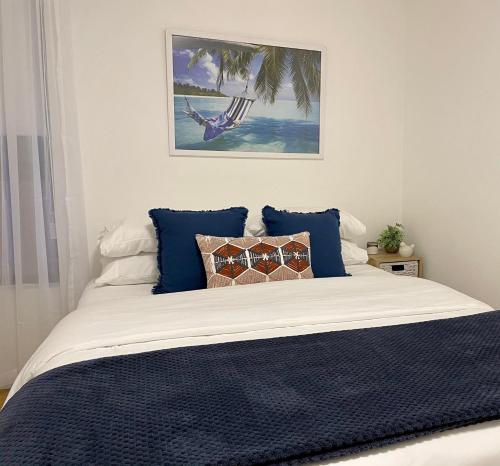 凯阿玛Kiama Palms on Collins的一间卧室配有一张带蓝色枕头的床