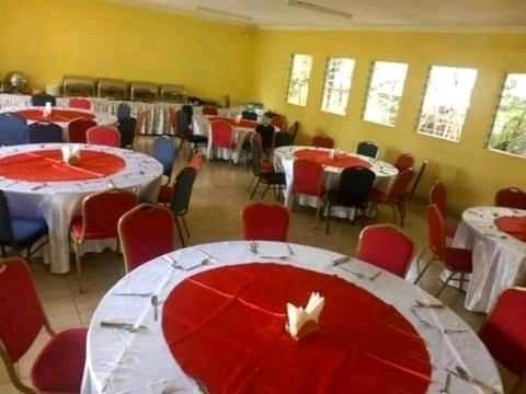 内罗毕Upper Hill Guest House Nairobi的一间设有红色和白色桌椅的房间
