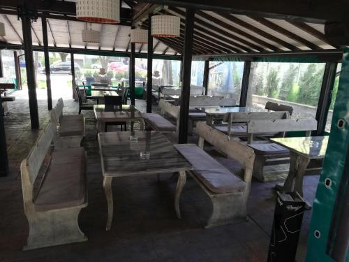维丁Hotel Ponti的餐厅设有木桌和长凳及桌子