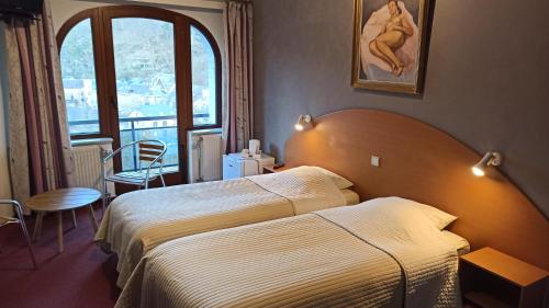 拉罗什-阿登乐木屋酒店的酒店客房设有床和窗户。