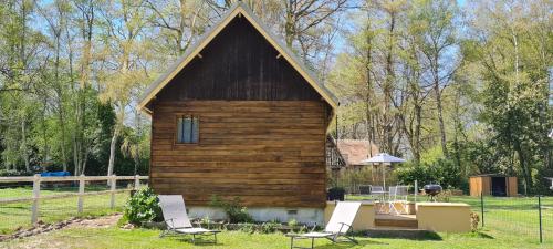Fierville-les-ParcsLa Cabane de Fierville的小木屋配有2把椅子和桌子
