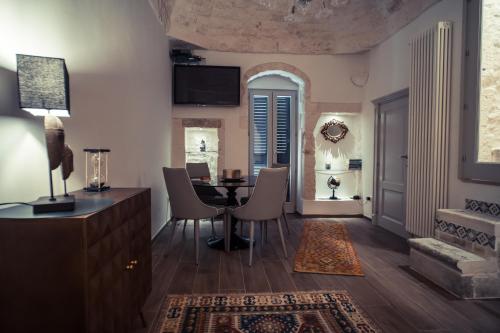 奥斯图尼800s Home Luxury Rooms的客厅设有餐桌和椅子