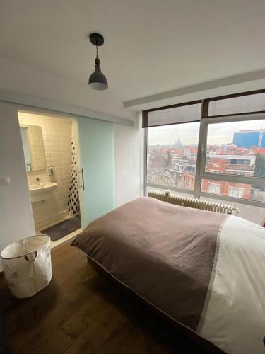 布鲁塞尔Brussels By Night panoramic studio apartment for 2的一间卧室设有一张大床和一个大窗户
