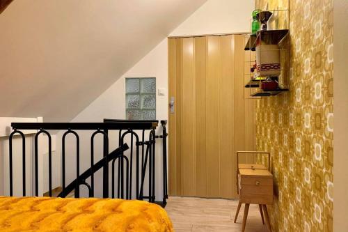皮埃尔丰Appartement Vintage avec vue sur le château的一间卧室设有黄色的床和楼梯。