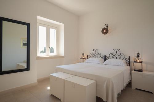 奥特朗托马赛利亚蒙特劳洛酒店的白色卧室配有床和镜子