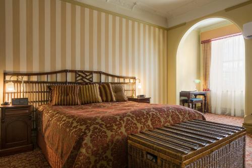 霍巴特哈德利东方酒店的一间卧室配有一张床,其中配有长凳