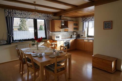 HildersFerienhof Spiegel的厨房配有木桌、椅子和桌子,还设有用餐室。
