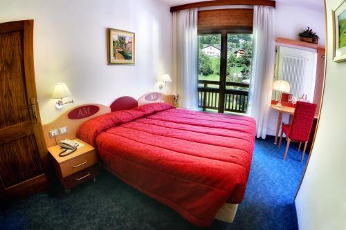 拉比阿尔伯戈米拉蒙蒂酒店的酒店客房配有红色的床和一张桌子