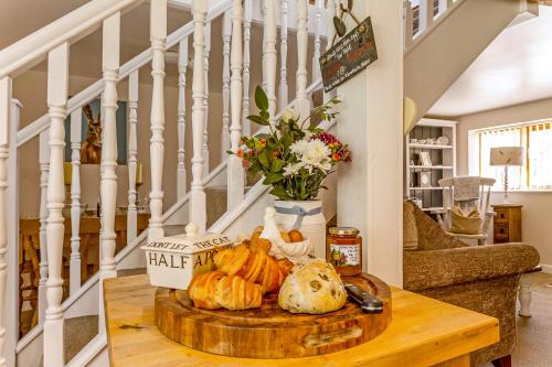 克哈尼伯尼Bridge Farm Holiday Cottages的客厅里一张桌子,上面有面包和南瓜