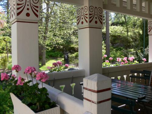 埃斯波Hotelli Tiiliriihi的一个带粉红色花卉和长凳的门廊