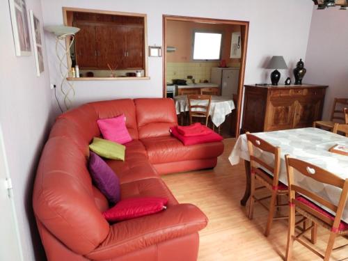 马雷讷Forestier的客厅配有红色皮革沙发和桌子