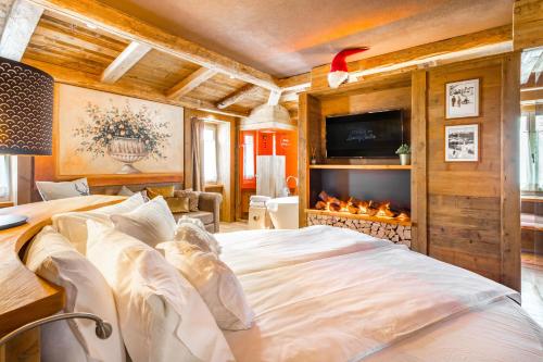 福尔加里亚John Luxury Suites的一间卧室设有一张大床和一个壁炉