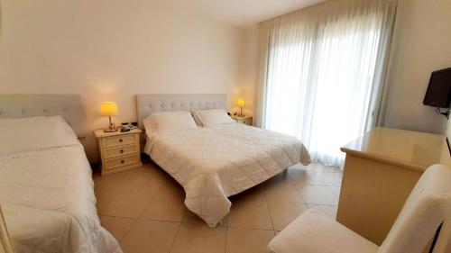 利尼亚诺萨比亚多罗弗拉伊皮尼酒店及健康中心的一间卧室设有两张床和窗户。