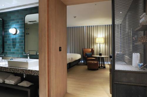 台南捷丝旅台南虎山馆的一间带水槽的浴室和一张位于客房内的床