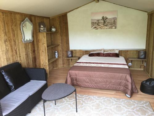 蓬蒂-达巴尔卡Glamping Cabana nas arvores的一间卧室配有一张床和一张沙发