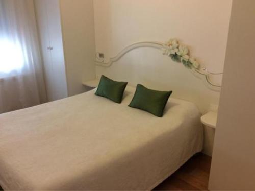 科内利亚诺Locanda Mezzosale的一间卧室配有一张带两个绿色枕头的床