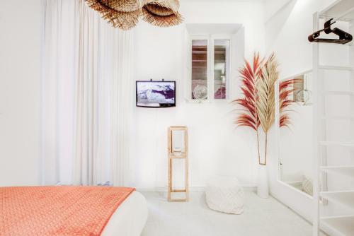 图卢兹Spa des Carmes的一间白色卧室,配有床和植物