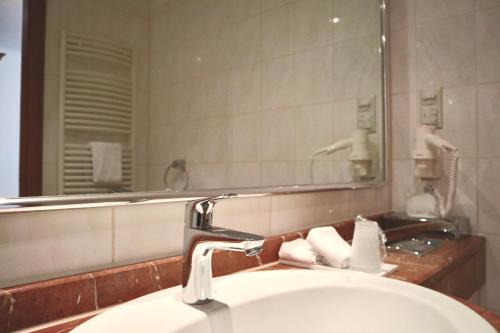 汉恩明登阿尔特帕克霍夫酒店的一间带水槽和镜子的浴室