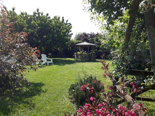 Saint-Dyé-sur-LoireLe Clos Joséphine的花园设有凉亭、椅子和鲜花
