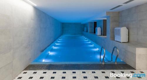 第比利斯Parilament on Rustaveli 4 rooms的浴室里设有蓝色灯光的游泳池
