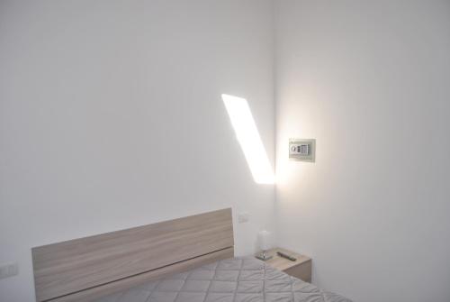 阿格里真托LE DIMORE DI DAMAROPE'的卧室配有一张床,墙上有灯