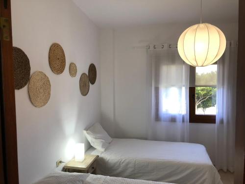 弗龙特拉Casa La Juyona的一间卧室设有两张床、一个窗户和一个吊灯。