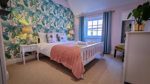 沃明斯特The Angel Holiday House的一间卧室配有一张带花卉壁纸的床