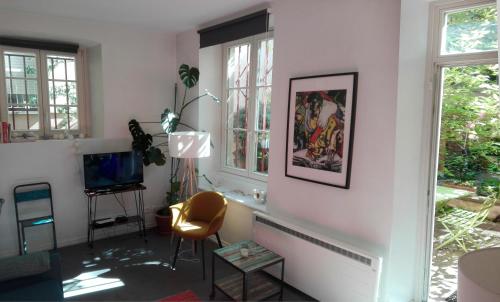斯特拉斯堡Appartement Petite France avec terrasse的客厅配有电视和椅子