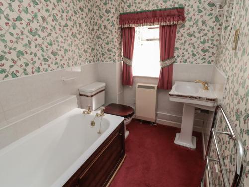 伍勒Rose Cottage的带浴缸和盥洗盆的浴室