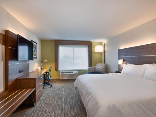 KeizerHoliday Inn Express & Suites Salem North - Keizer, an IHG Hotel的酒店客房设有一张大床和一台电视。