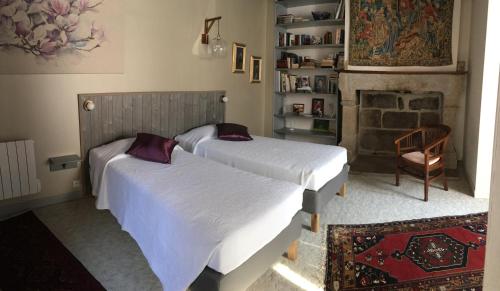格朗维尔La Maison des Matignon 1的卧室设有两张床,配有壁炉