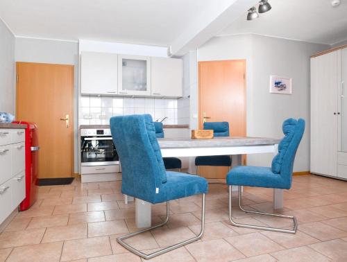高尔维茨FIP Park Leuchtturmblick的厨房配有桌子和蓝色的椅子