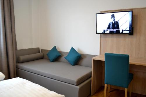 兰纳赫Gasthof Kranerwirt的一间配有沙发的房间和墙上的电视