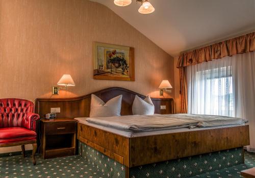 塞巴特阿尔贝克Hotel Meereswelle - Anno 1875的一间卧室配有一张大床和一张红色椅子