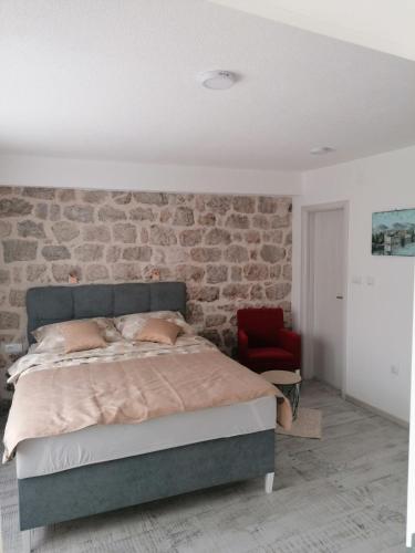特雷比涅VILA MIRA的一间卧室设有一张床和砖墙