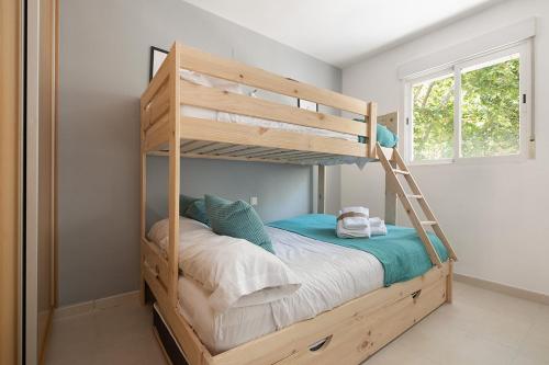 马略卡岛帕尔马Toros Apartamentos的一张木制双层床,在房间内配有梯子