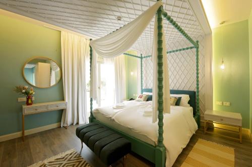 斯库台Çoçja Boutique Hotel的一间卧室配有天蓬床和镜子