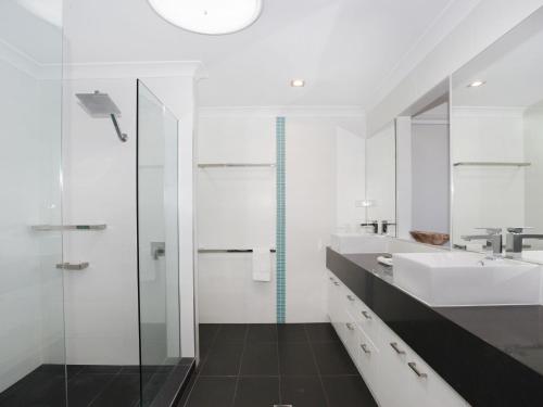穆卢拉巴4 bedroom home on canal的白色的浴室设有水槽和淋浴。