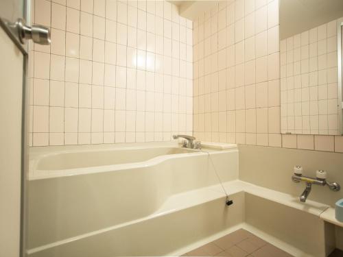 高松辛卡巴卡瓦观光酒店的白色的浴室设有浴缸和水槽。