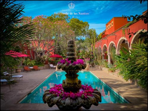 阿拉莫斯哈森达桑托酒店的游泳池旁的喷泉,有粉红色的花朵